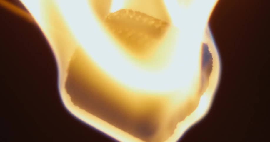 Slow motion footage of intense yellow flames on the tip of a fire staff