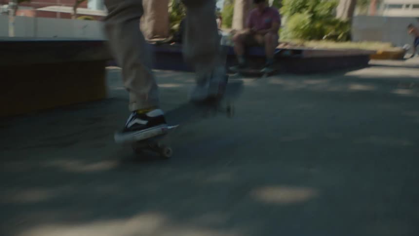 Young teen man riding a skateboard on a park in the city at daytime