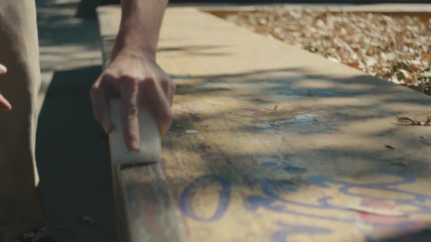 A person is waxing a piece of wood