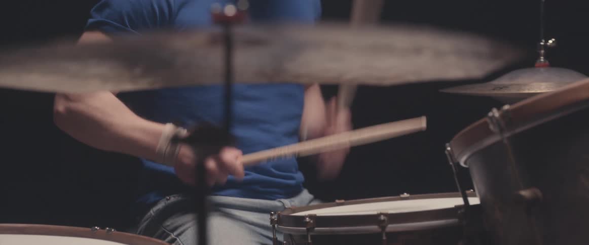 A man closes his eyes while playing the drums