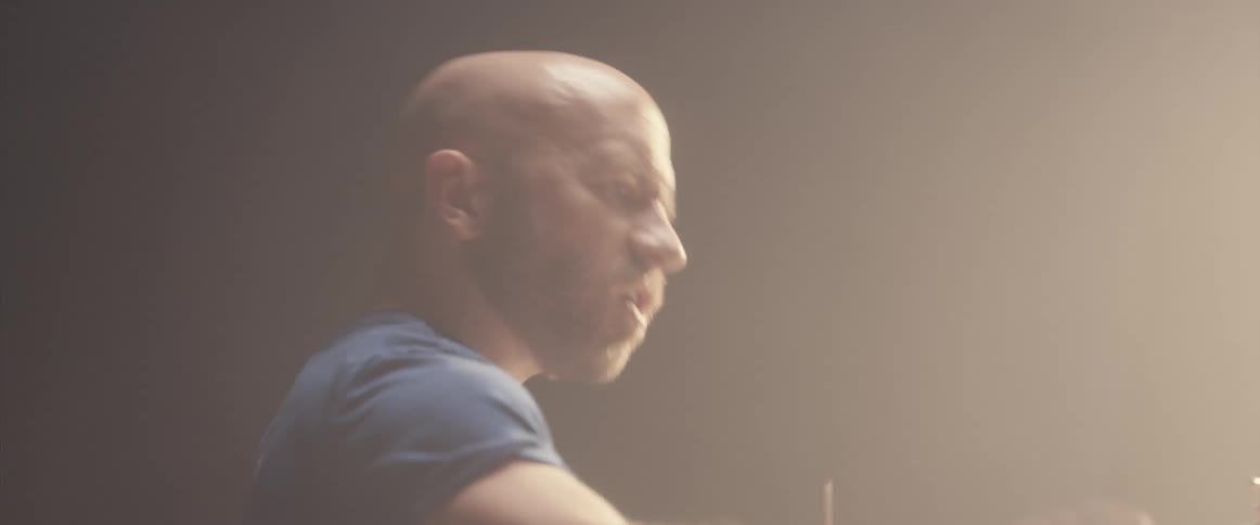A man is playing the drums indoors