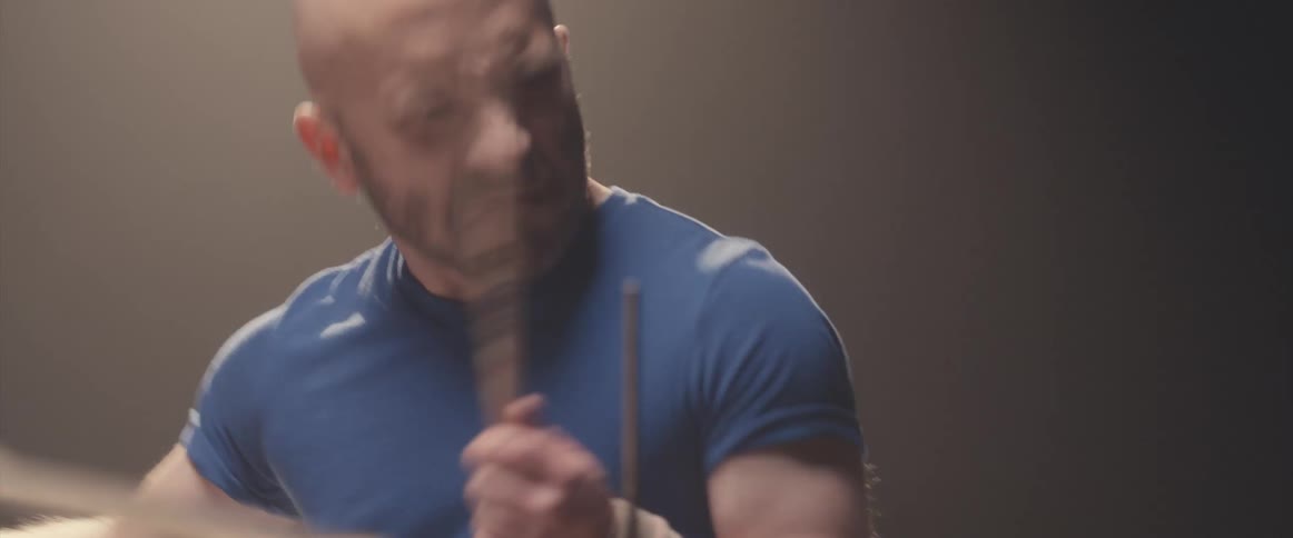 A musician is holding drumsticks and keeping the rhythm playing the drums and cymbals