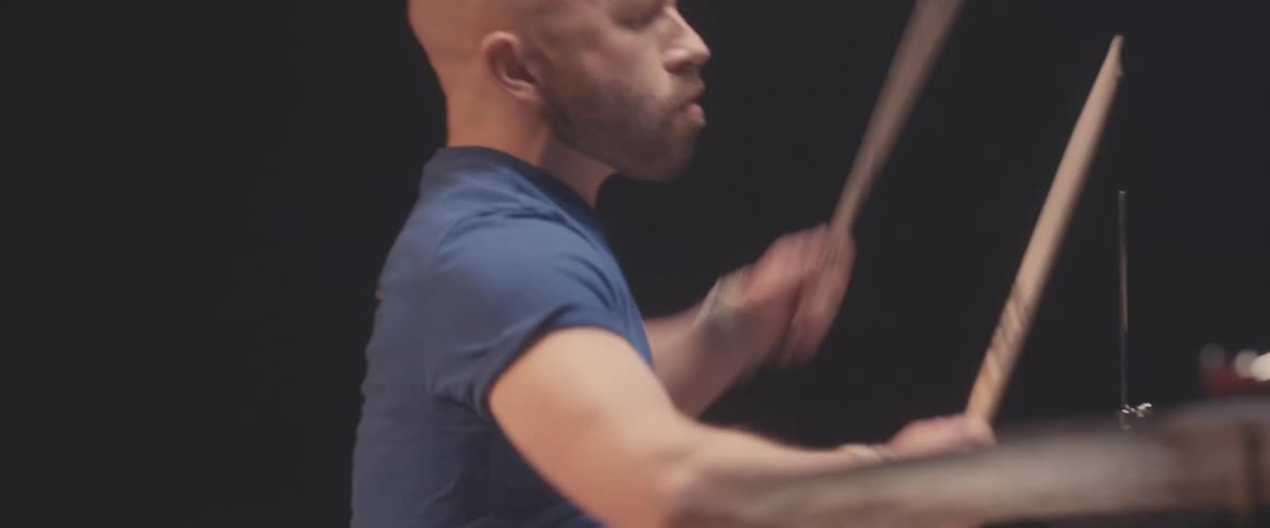 A man is playing the drums in a room