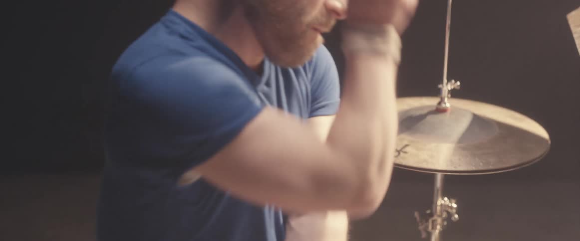 A man moves to the beat as he plays the drums