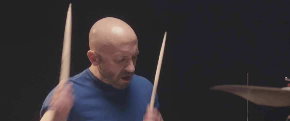 A man is playing the drums in a room indoors