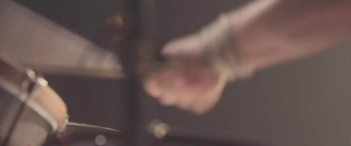 A man is playing the drums instrument indoors