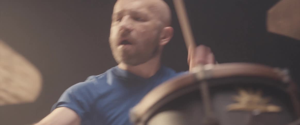 A drummer plays a drum set in a dark place