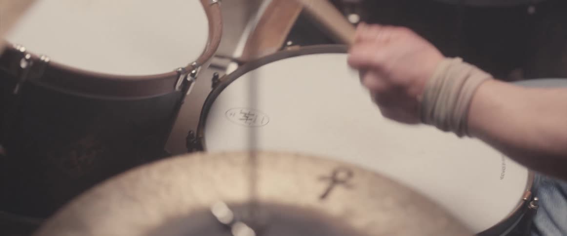 A musician is holding drumsticks and keeping the rhythm playing the drums