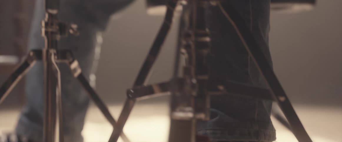 A person is playing the drum set indoors