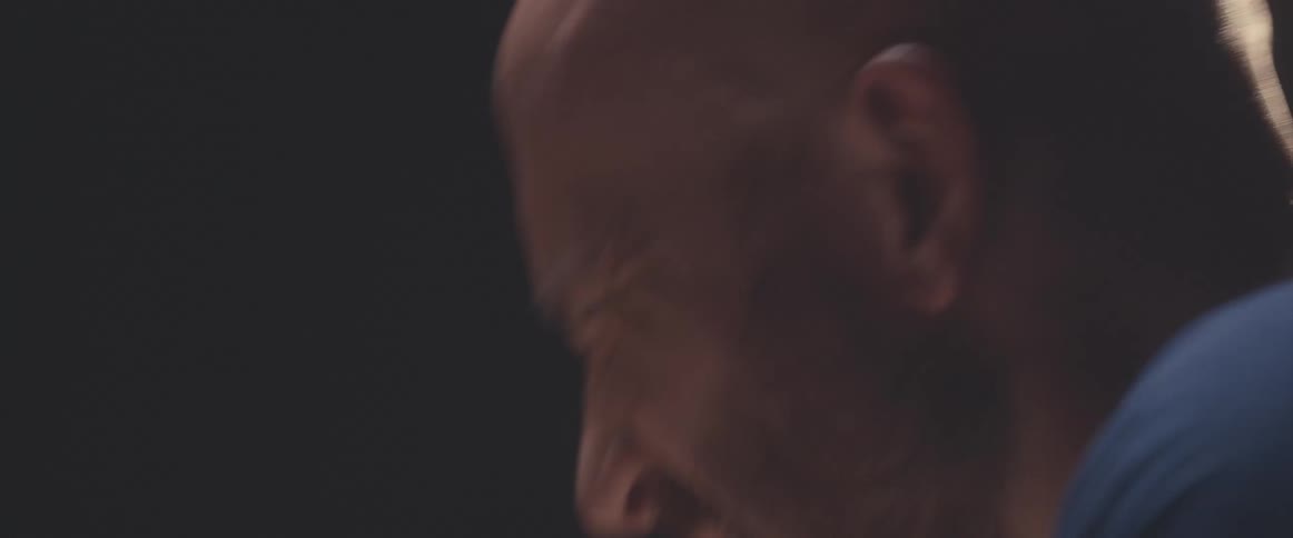A man nods his head to the beat while playing the drums