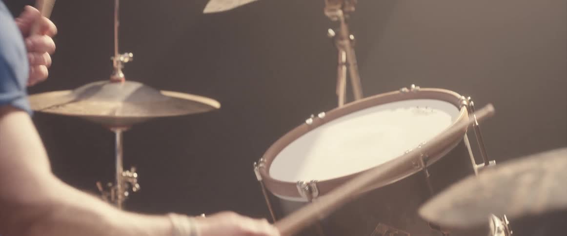 A man playing the drums with emotion on his face