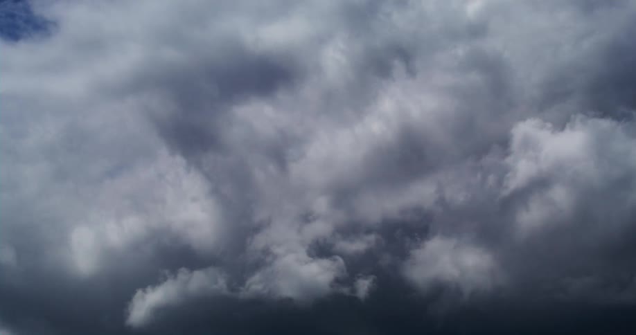 Clouds are moving across a deep blue sky and they are getting darker