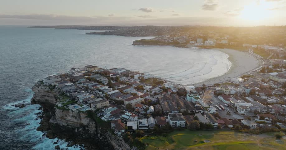Aerial view of coastal city and bay at sunset