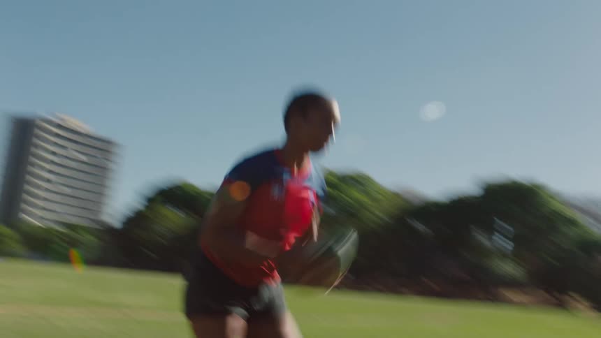 Woman catches football and runs toward goal post