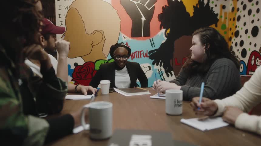 A woman sits down at the conference table