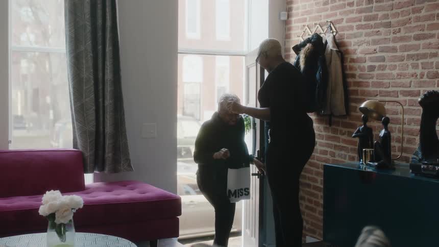 Daughter opens the door to greet her mother with a hug at home