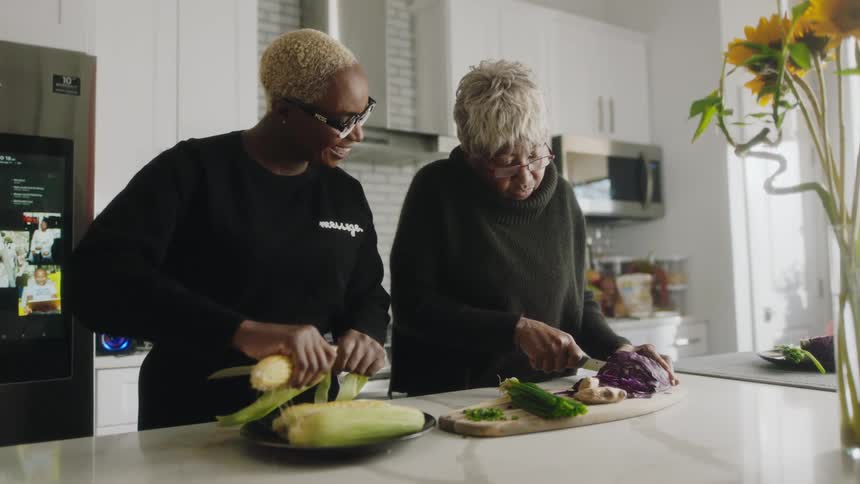 Mother and daughter cooking vegetables together on the kitchen at home