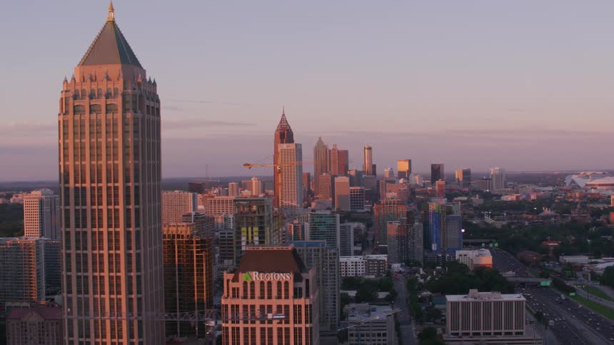 The sun shines brightly on tall buildings and skyscrapers overlooking a big city