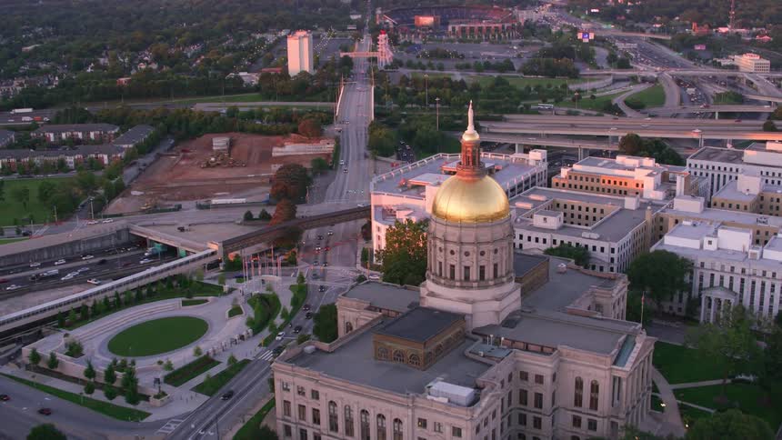 Traffic passes along street and controlled access highway passing landmark building with golden dome