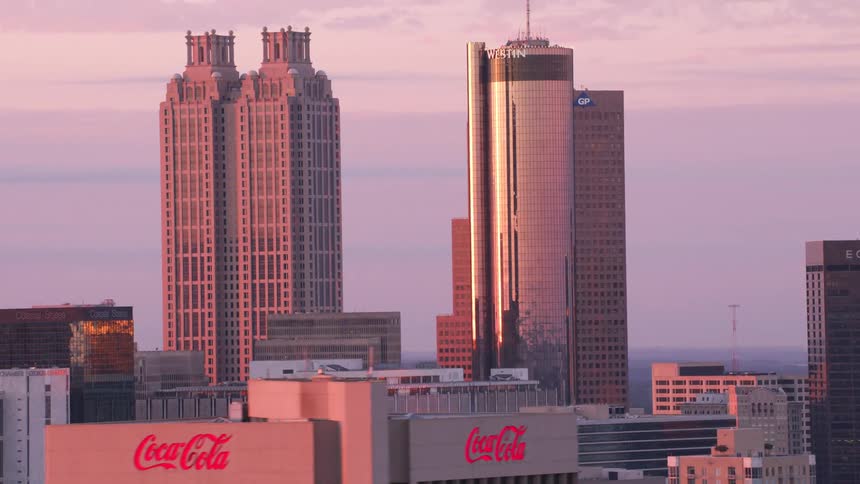 The sun shines brightly on tall buildings overlooking a big city