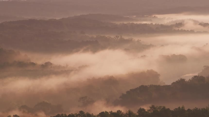 An aerial view of a mountain range with clouds