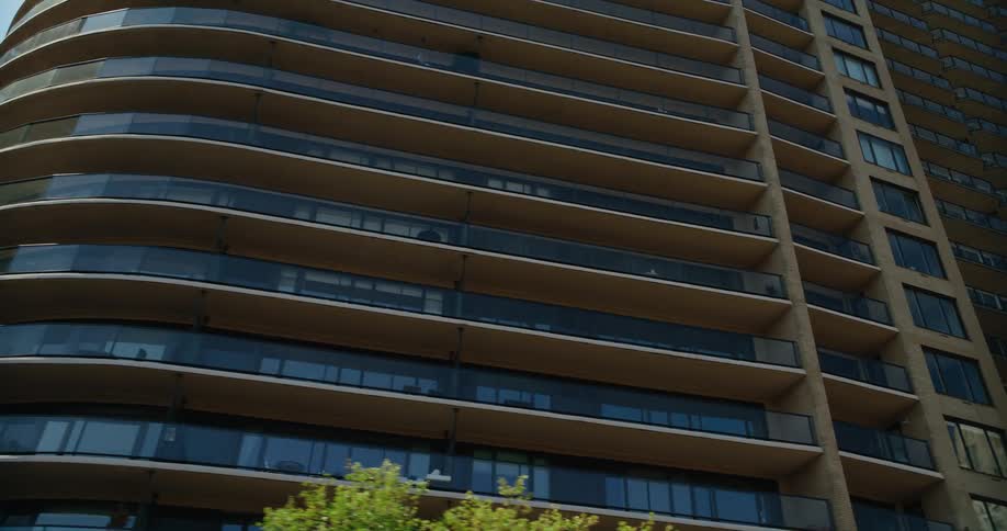 Apartment building glass reflects bright sunlight in tower block