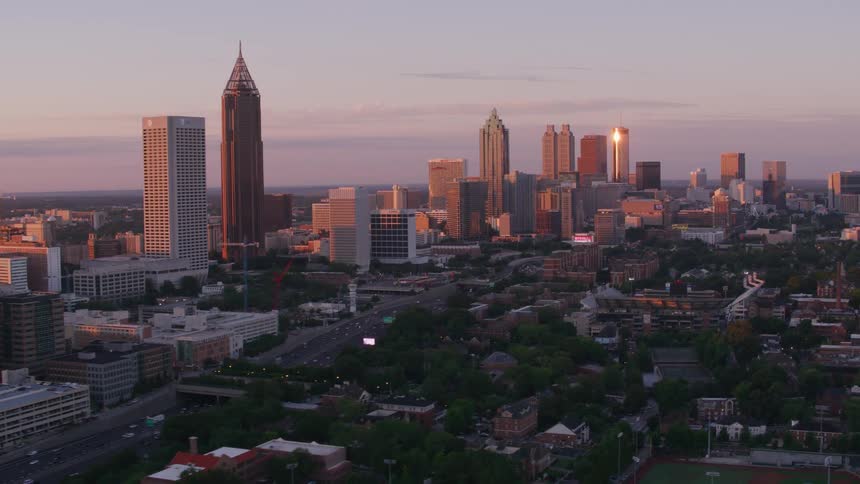 Sun is setting over buildings and skyscrapers in a big city