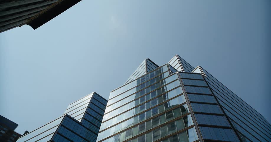 Sunlight is reflecting off of the windows of a tall building in a city