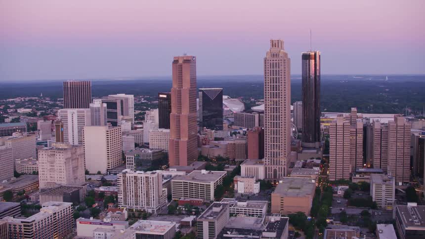 Sunlight shimmers off tall skyscrapers at sunrise