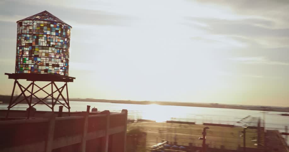 A stained glass water tower sits on the rooftop of a building along the coast near downtown