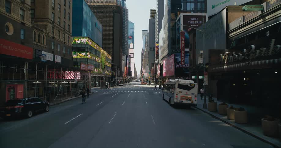 Vehicle drives through city street with high rise buildings