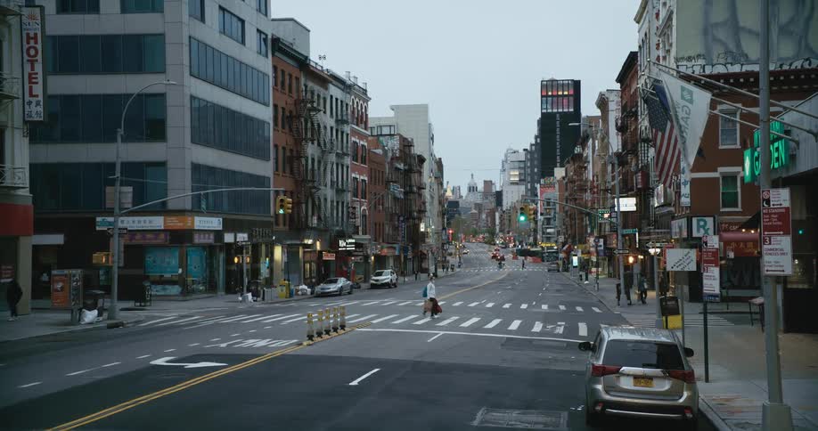 People carrying shopping bags cross the street in a desolate city