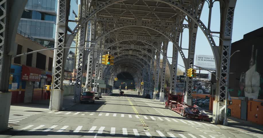 Beams of an elevated subway track over the empty city streets