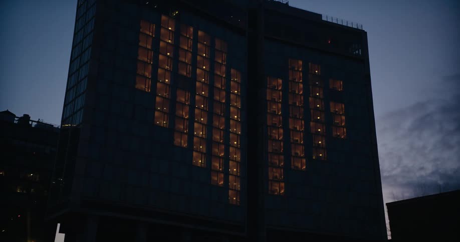 Silhouette of a building with lights in the shape of a heart at evening