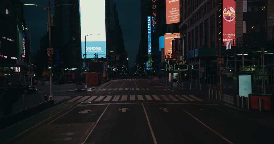 Video billboards light up an empty city street at night