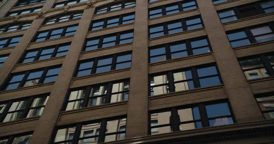 The buildings across the street are brightly and clearly reflected on the facade windows