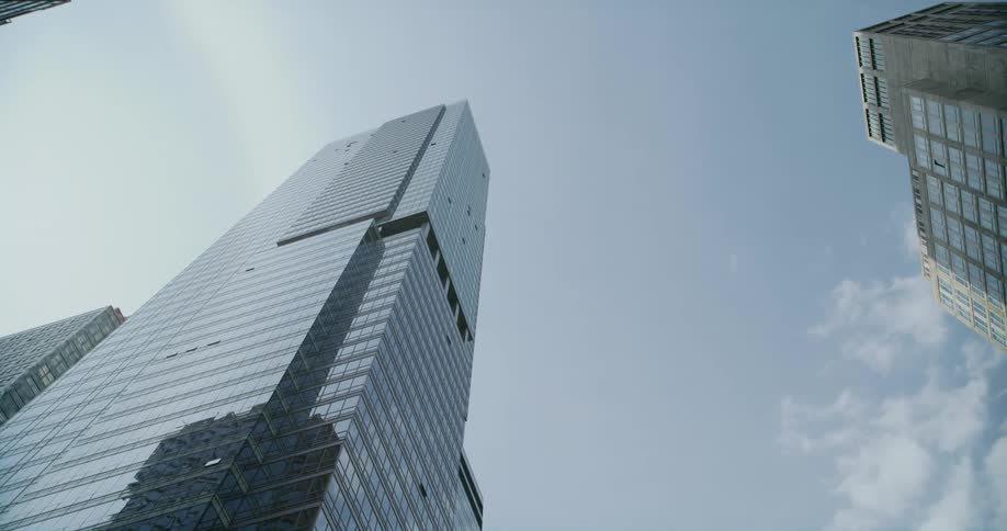 Skyscrapers reflect off the mirrored surface of a taller skyscraper