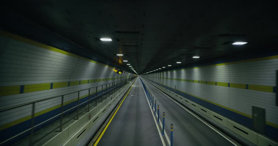 Traveling through an empty tunnel with lights on the ceiling