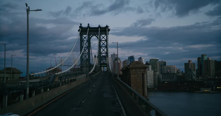 A vehicle drives along a bridge headed toward downtown