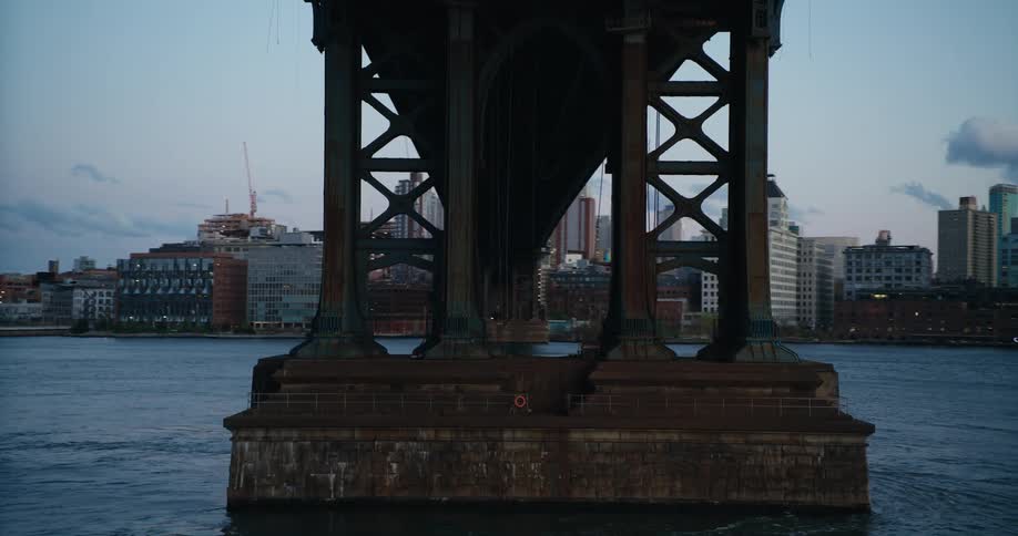 Traveling under the manhattan bridge in new york city at sunset