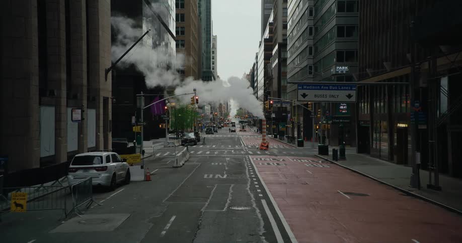 A wide street between tall buildings in a metropolis during the day