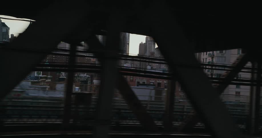 New york city skyline behind the beams of a bridge at morning
