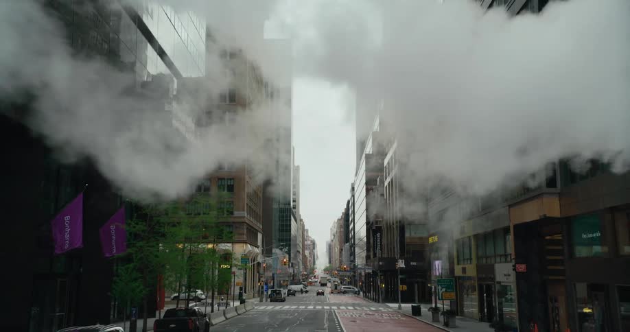 Orange heating system pipe pouring steam from new york city streets at morning