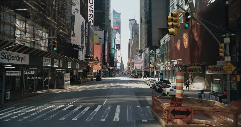 Vehicle drives through city street with billboards in downtown