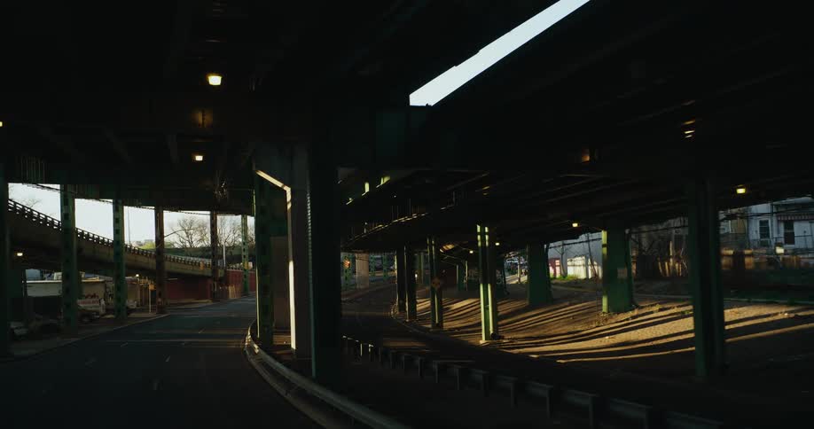 Square columns hold up train tracks going around a curve in a city
