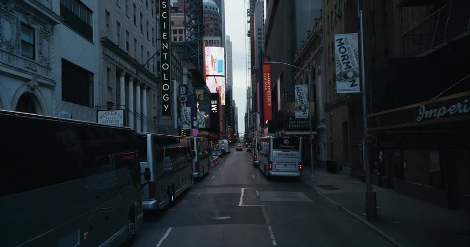 Travel buses are parallel parked along a city street