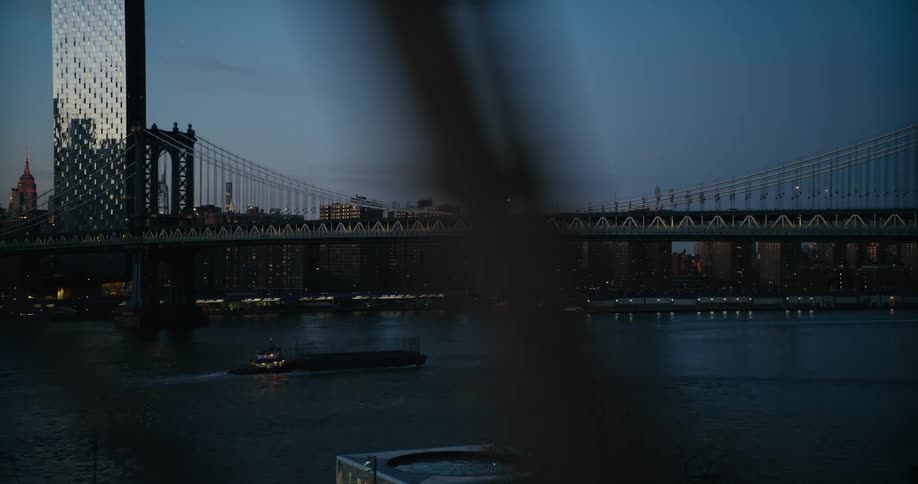 A ferry sails under a bridge as it heads toward downtown