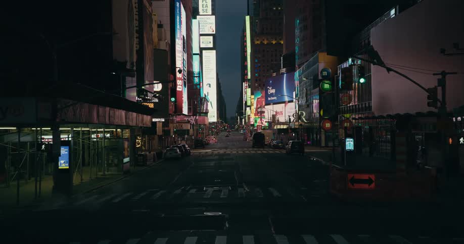 Vehicle drives on empty streets in downtown with billboards in the city