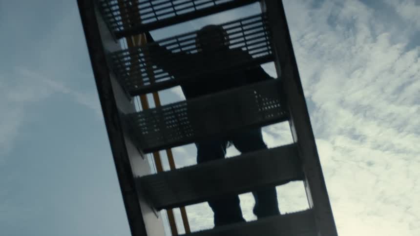A man is climbing a tall set of stairs