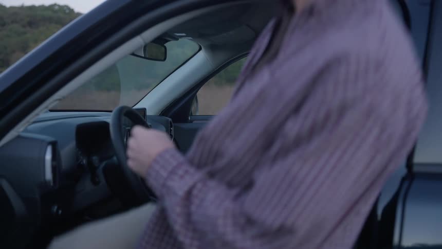 A man and woman smile at each other when getting into their truck
